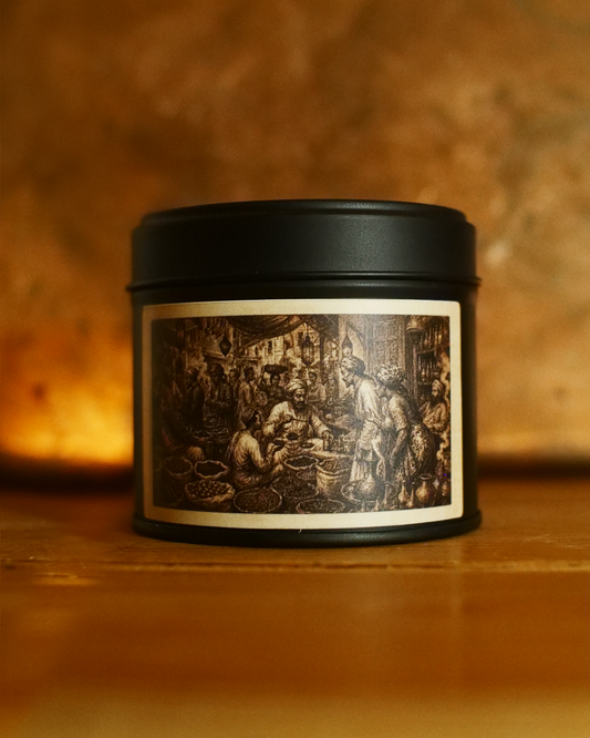 Zanzibar Spice Bazaar candle in a matte black tin, lid on, with an etched label of a crowded spice market — traders, hanging lanterns and open sacks of spice — Wayward