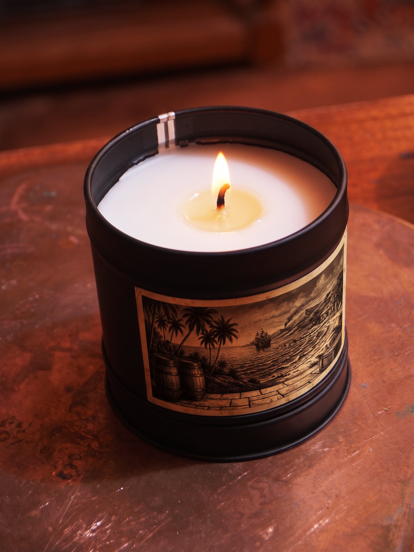 Caribbean Rum Shack scented candle by Filthy Candles, lit in a black tin with tropical harbour illustration