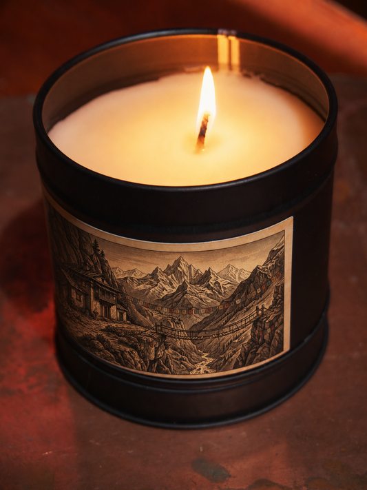 Himalayan Monastery scented candle by Filthy Candles, lit in a black tin with mountain monastery illustration