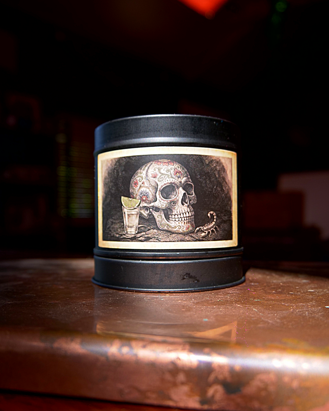 Mexican Tequila Bar candle in a matte black tin, lid on, with an etched label of a decorated calavera beside a tequila shot and lime — Wayward