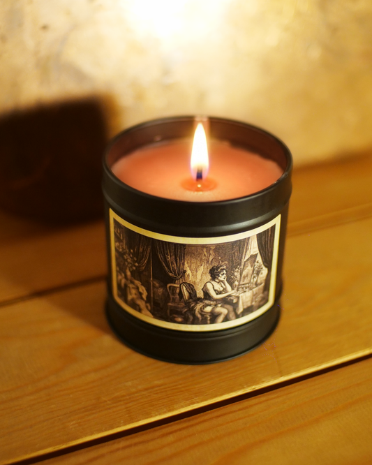 risian Boudoir candle burning with deep red wax, close on the etched label of a dressing room — heavy drapes, a vanity mirror, a woman at her table — Wayward