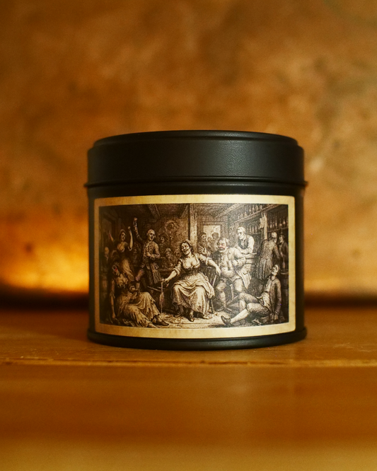 Victorian Gin House candle in a matte black tin, lid on, with an etched label of a riotous gin-house interior — Wayward