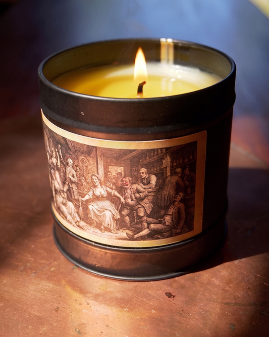 Victorian Gin House candle burning above a gold-bordered etched label of a crowded 18th-century tavern — Wayward