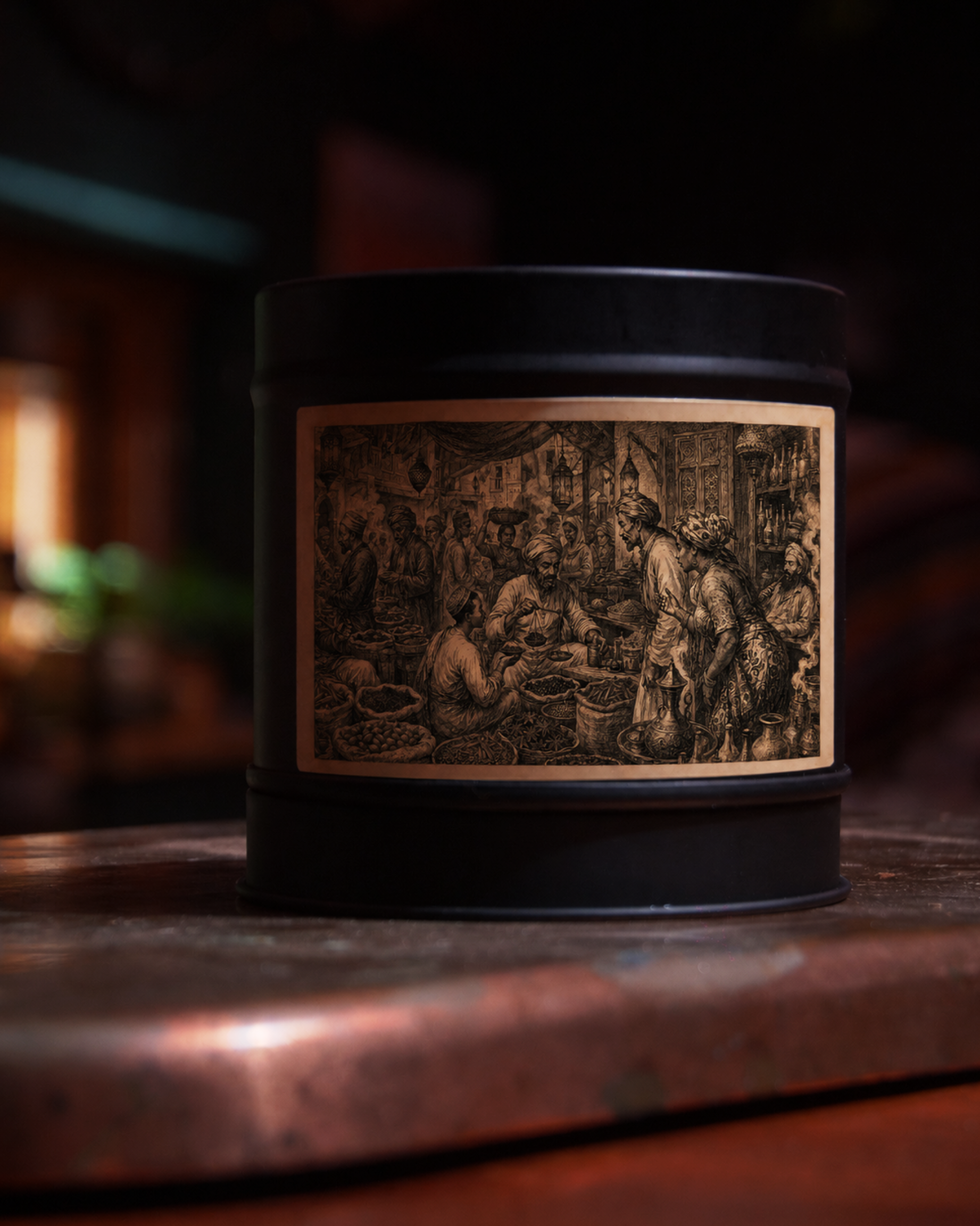 Zanzibar Spice Bazaar candle in a matte black tin, lid on, with an etched label of a crowded spice market — traders, hanging lanterns and open sacks of spice — Wayward