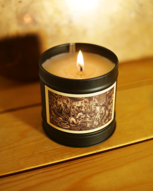 Zanzibar Spice Bazaar candle burning, close on the etched market label with brass scales and spice baskets — Wayward